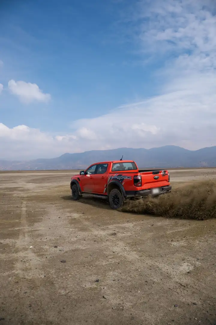 Ranger Raptor Lava Orange de Don Romanov derrapando en un llano de tierra